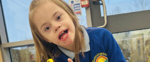 Child in Sunningdale school uniform sitting in a classroom looking into the camera